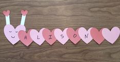 the word calisto is spelled out in pink paper with hearts attached to it on a wooden surface