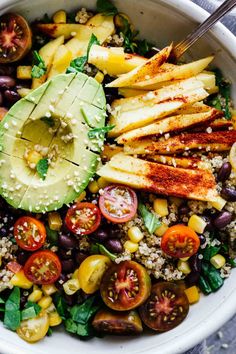 a salad with avocado, tomatoes, black beans and other vegetables in it