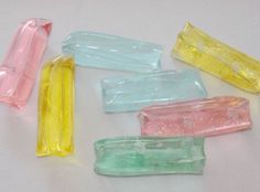 several different colored candy sticks on a white surface