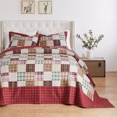 a bed covered in a red and white checkered comforter next to a nightstand