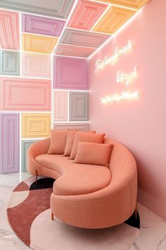 a pink couch sitting in front of a wall with neon lights on it's sides