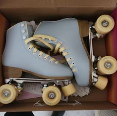 a pair of roller skates sitting in a box with wheels on the bottom and inside