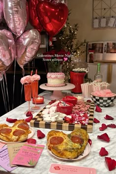 a table topped with lots of food and balloons