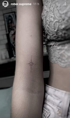 a woman's arm with a small star tattoo on the left side of her arm