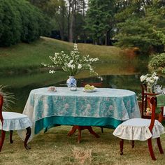 the table is set with two chairs and a blue cloth covered tablecloth on it