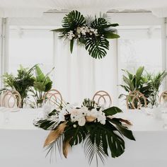 the table is set with white flowers and greenery for an elegant wedding breakfasteon