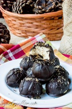 chocolate covered desserts on a plate with pine cones in the background and plaid table cloth