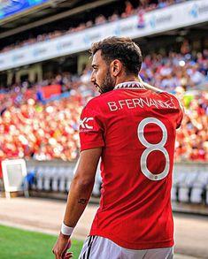 a man in a red shirt is standing on the field