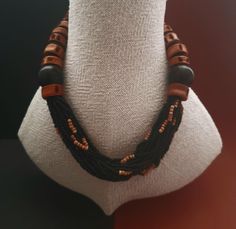 An opulent Necklace with fish vertebrate and ebony beads.Pierced fish vertrebrate are allready known as jewelry from the neolithic era. Rocailles beads made of glass and clay are inserted in the center. Size of ebony bead: 23 mm Length: 52 cm or 20,47 inch Adjustable Brown Necklace With Black Beads, Artisan Necklace With Brown And Black Beads, Unique Black Polished Bead Jewelry, Traditional Brown Jewelry With Black Beads, Unique Black Jewelry With Polished Beads, Artisan Brown Spacer Beads, Handmade Black Oval Beads Jewelry, Unique Wooden Beads For Jewelry Making, Handmade Black Jewelry With Oval Beads