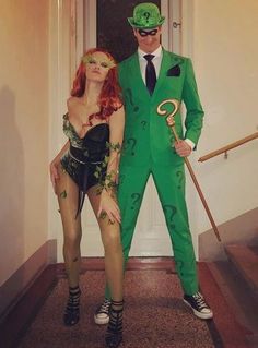 two people dressed up in costumes standing next to each other on the stairs at an entrance way