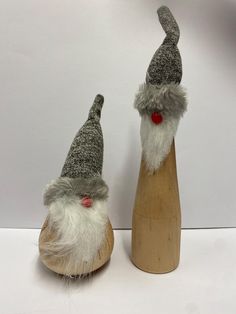 two small gnomes sitting on top of wooden bases