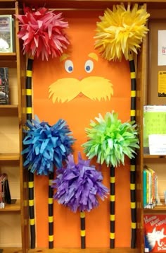 a bulletin board with paper pom poms in the shape of a man's face