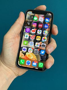 a person holding an iphone in their hand with icons on the screen and app icons on the back