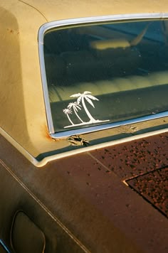 an old car with a palm tree sticker on it