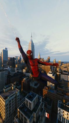 a spider man flying through the air over a city