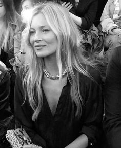 black and white photograph of woman sitting in crowd