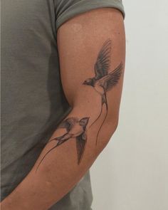 a man with a bird tattoo on his arm