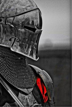 black and white photograph of a knight in full armor with red lining on his helmet