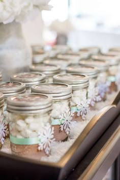 mason jars filled with white flowers and snow flakes