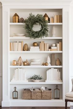 a bookshelf with christmas decorations and wreath on the top shelf in front of it