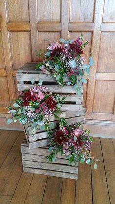 three wooden crates with flowers in them on the floor