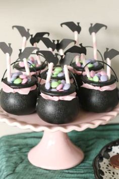 black and pink desserts with bats on them are sitting on a cake platter