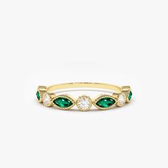 a gold ring with green and white stones