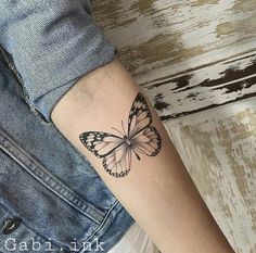 a woman's arm with a butterfly tattoo on the left side of her arm