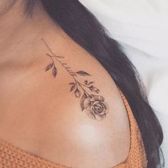 a woman with a rose tattoo on her upper arm and shoulder is laying down in bed