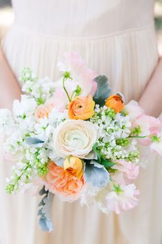 a woman holding a bouquet of flowers in her hands