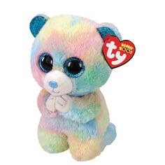 a rainbow teddy bear with big eyes and a tag on it's ear,