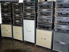 many amps are lined up against the wall