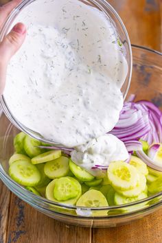 a bowl filled with cucumbers, onions and ranch dressing