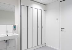 an empty bathroom with several stalls and sinks in the corner, along with mirrors on the wall