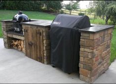 an outdoor bbq grill made out of pallets and wood with a black cover over it