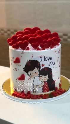 a cake decorated with two people and hearts on the top is sitting on a table