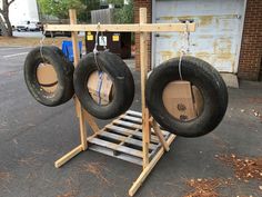 two tires are hanging from a wooden rack