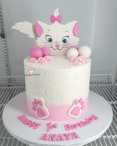 a white cake with pink frosting and an image of a cat on top