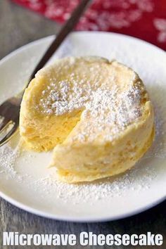 a white plate topped with two pieces of cheesecake next to a fork and knife