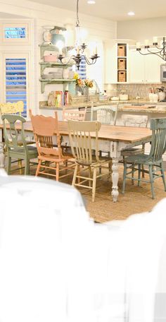 a dining room table and chairs in front of an open kitchen with lots of counter space