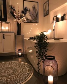 a bathtub with candles and flowers in the corner, next to a round rug