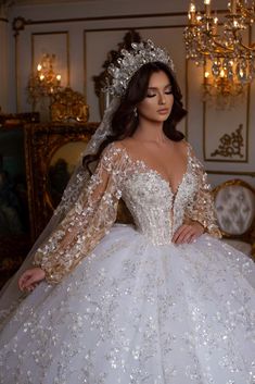 a woman in a wedding dress standing next to a chandelier