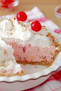 a piece of pie with cherries on top is sitting on a plate next to the rest of the pie