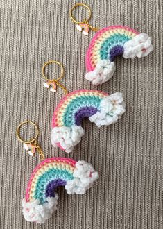 two crocheted rainbow keychains on a gray surface