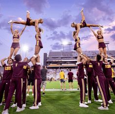 a group of cheerleaders doing tricks on the field