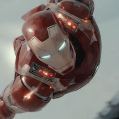 an iron man flying through the air with his head turned to look like it has glowing eyes