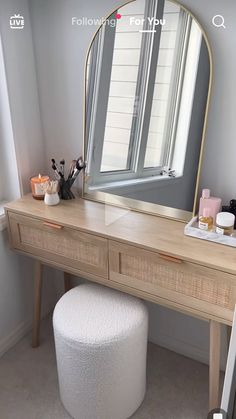 a vanity with a large mirror and stool in front of it, next to a window