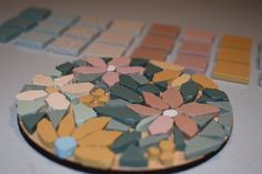 there is a plate that has flowers on it and many other tiles in the background