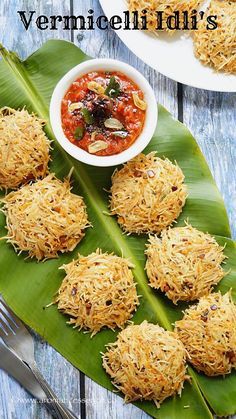 some food is sitting on top of a banana leaf next to a bowl of sauce