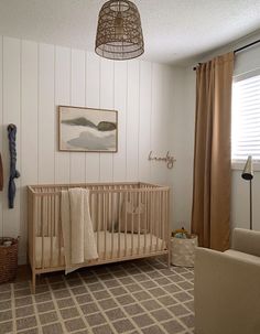 a baby's room with a crib, rocking chair and pictures on the wall